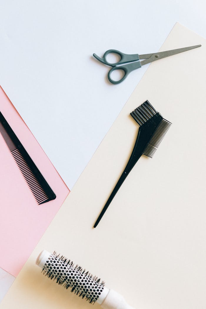 Top view of assorted hairdressing tools on a colorful background.