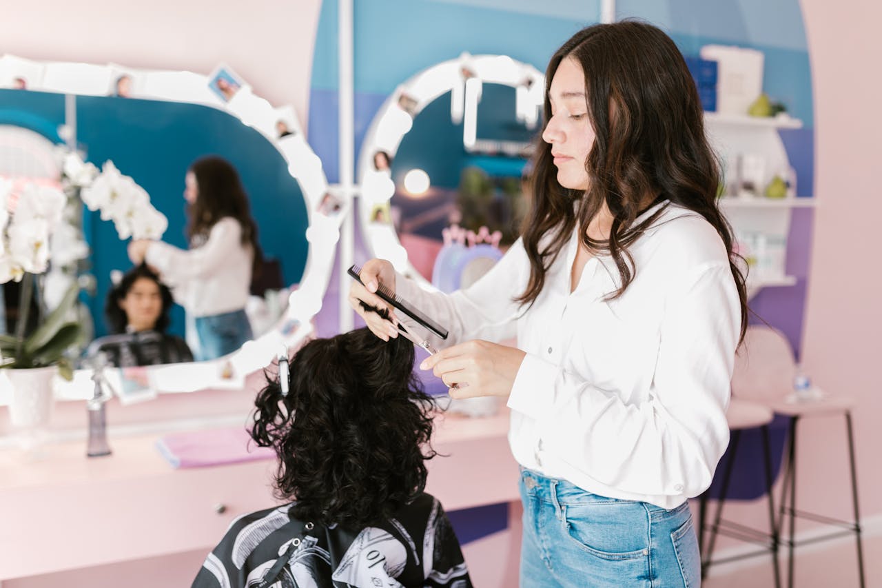 A hairdresser in a modern salon skillfully trims a womans hair.